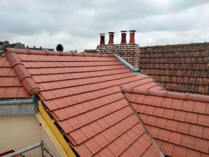 Artisan posant des tuiles sur un toit