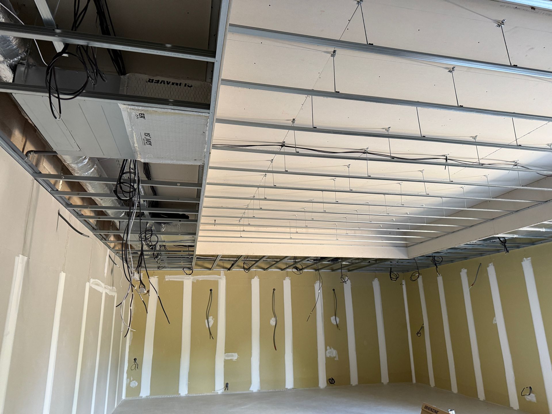 Aménagement intérieur : plafond et murs à ossature métallique avec cloisons sèches partiellement installées.