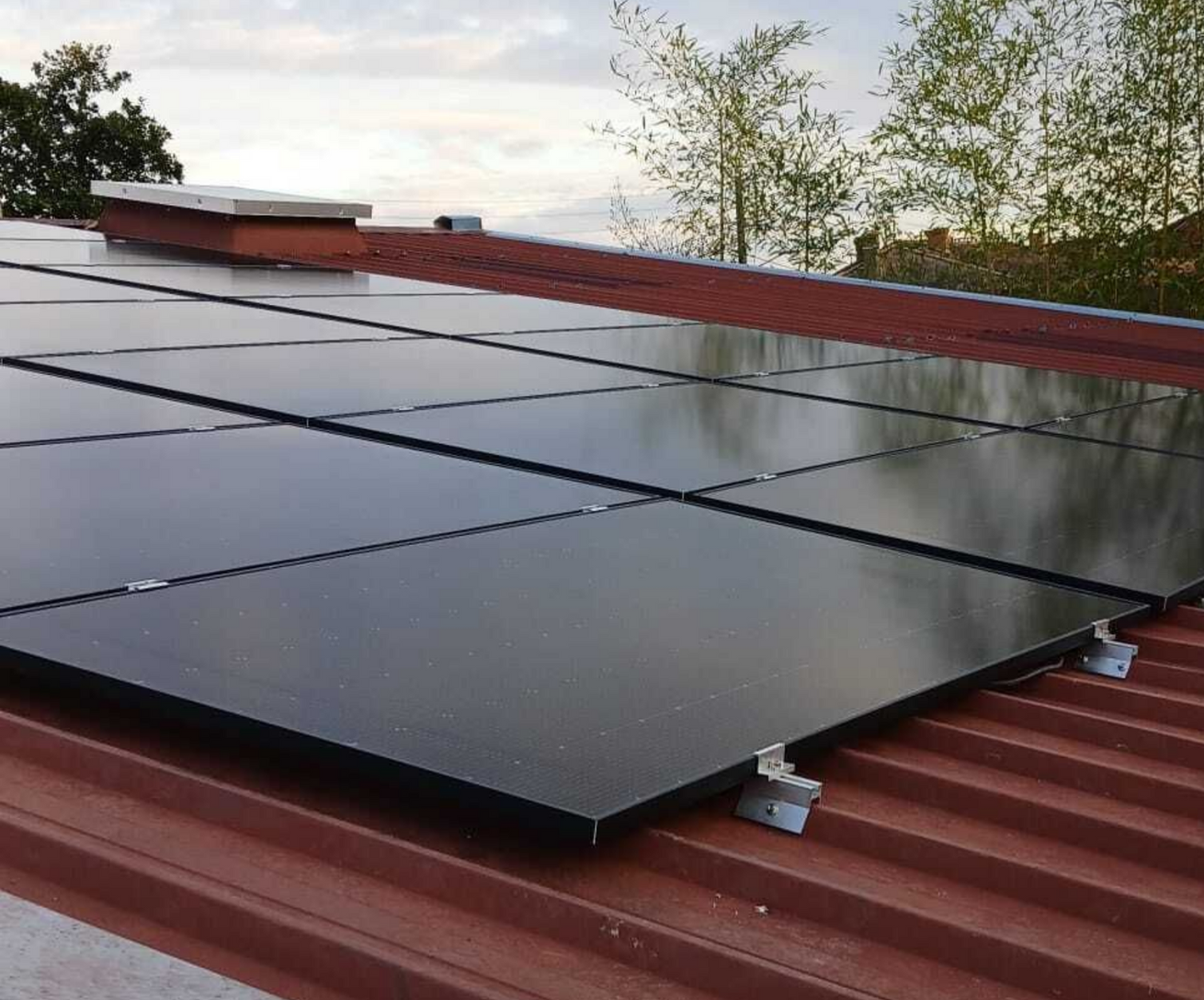 Un homme tenant un enfant, pointant du doigt des panneaux solaires sur le toit d'une maison.