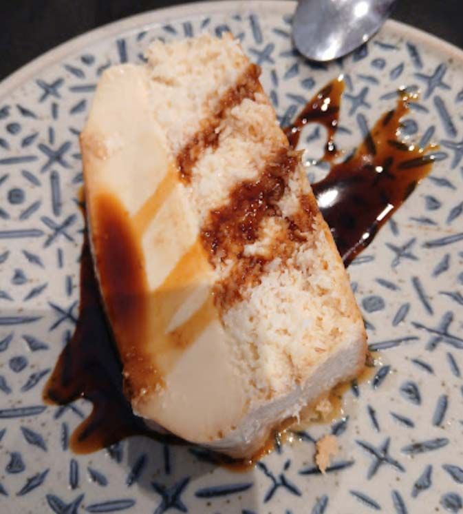 Un trozo de pastel en un plato con una cuchara.