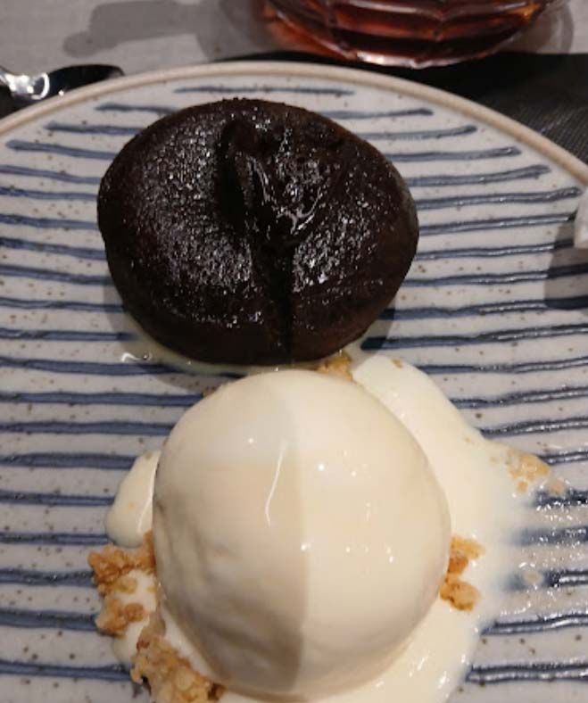 Un pastel de lava de chocolate y una bola de helado en un plato