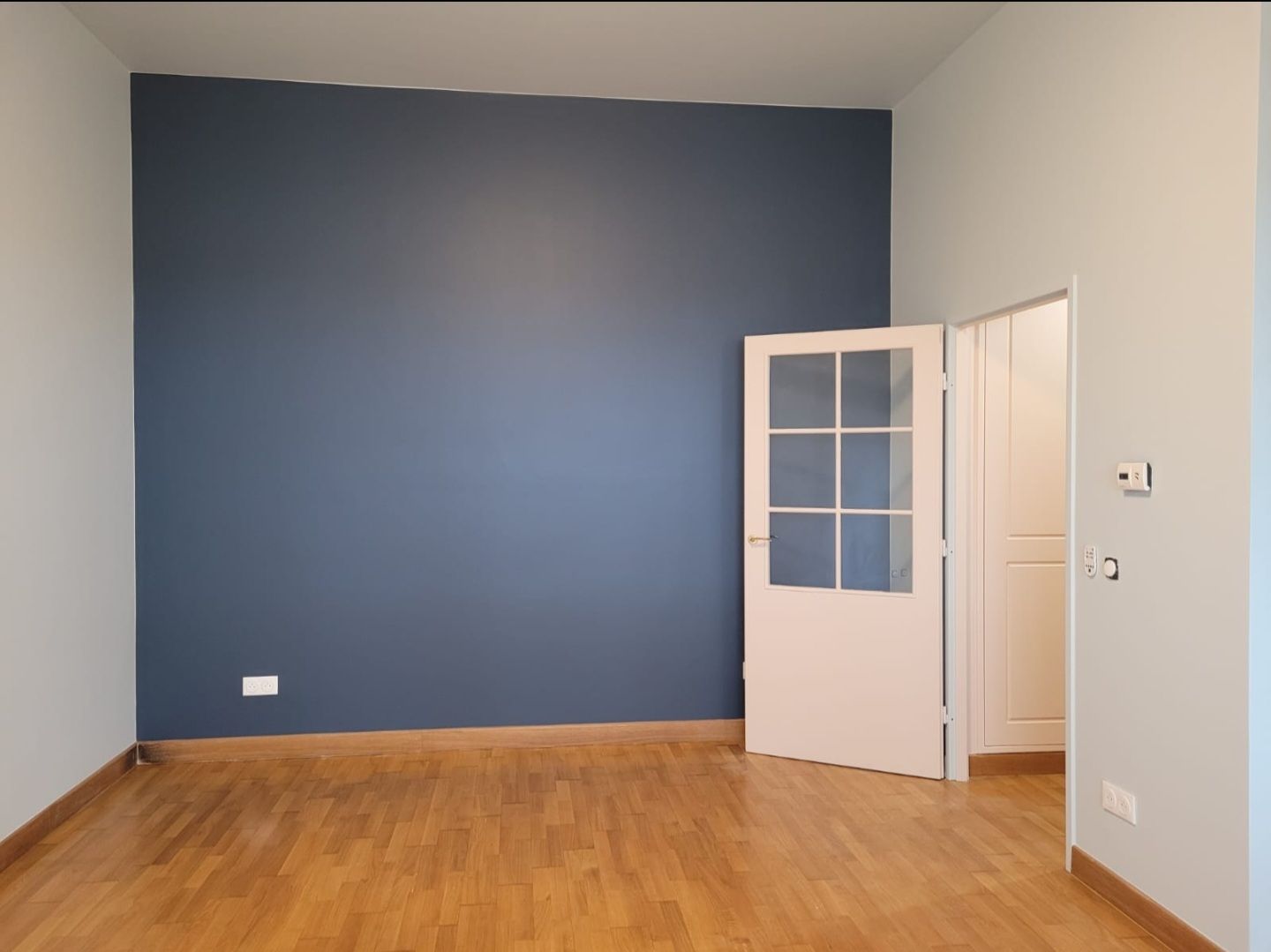 Peinture bleue dans chambre avec porte beige