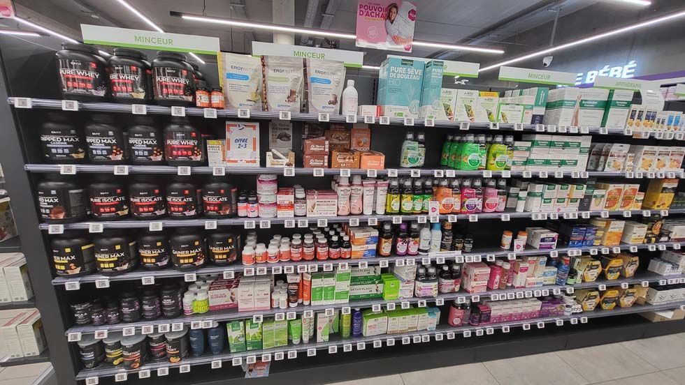 Des rayons dans un magasin remplis de divers compléments alimentaires et produits de santé.