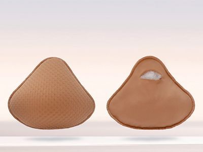 Deux prothèses mammaires, beiges, en forme de larme, l'une texturée, l'autre ouverte.