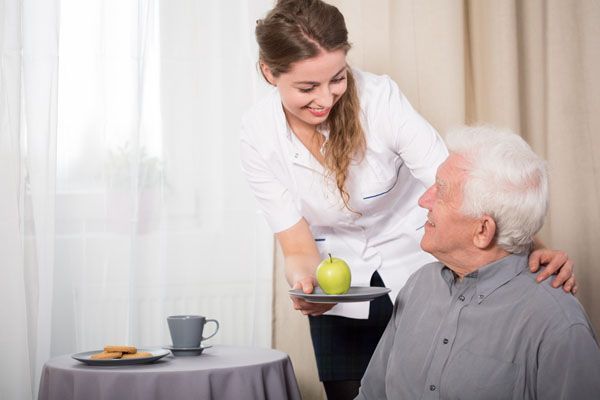 Lit dans une chambre d'un blanc immaculé, avec une couverture à carreaux violets et un oreiller blanc.