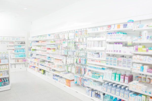 Intérieur d'une pharmacie avec des étagères garnies de divers produits.