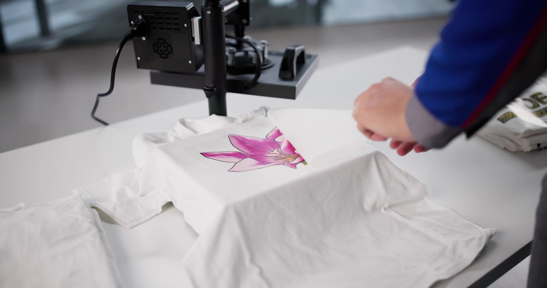 Une personne apporte les dernières touches à un motif imprimé sur un t-shirt blanc, prêt pour l'impression.