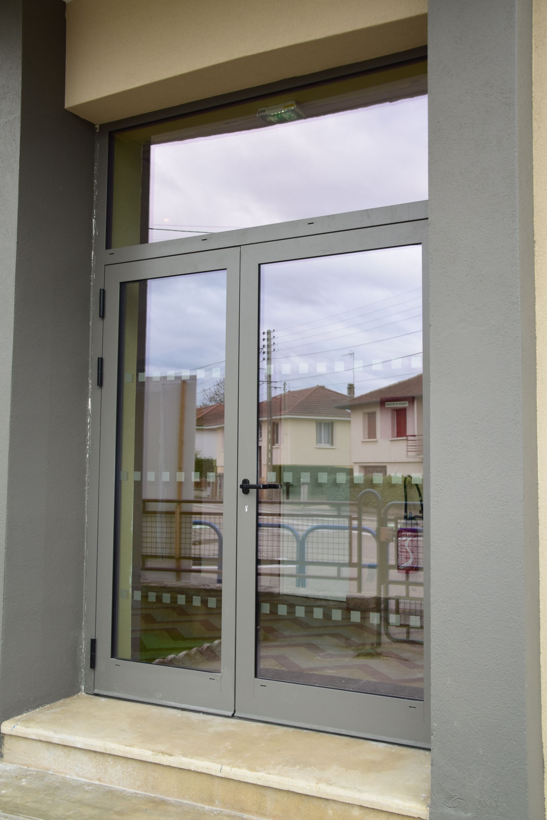 Porte d'entrée en aluminium grise à double vantaux