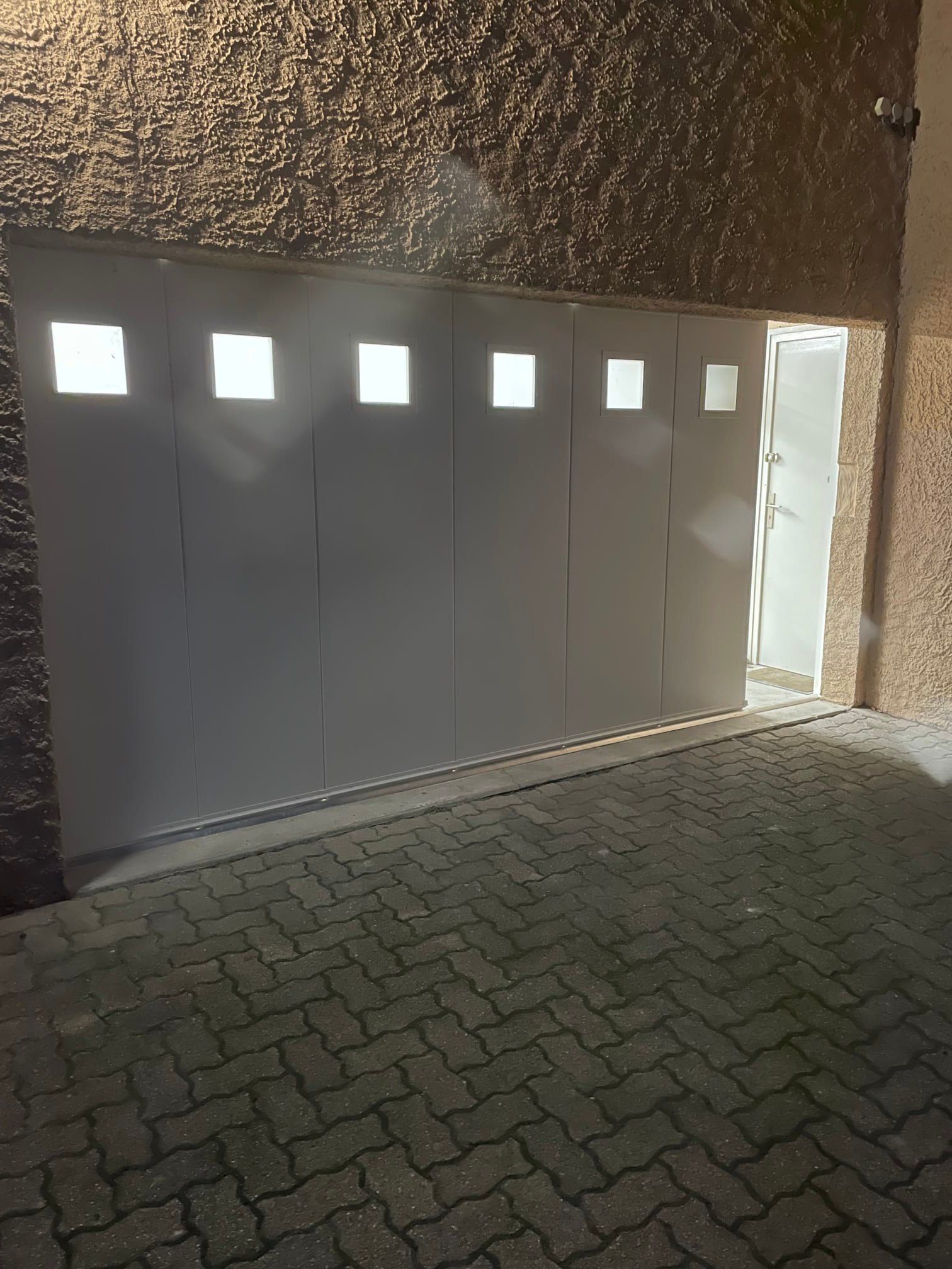 Porte de garage blanche à petites fenêtres