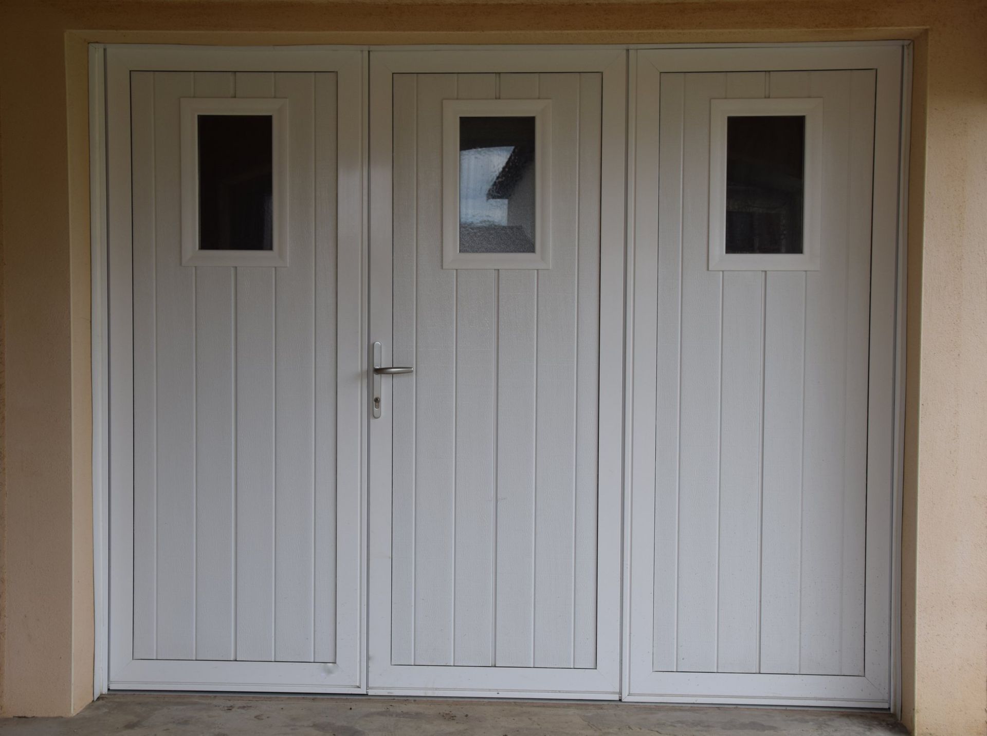 Porte de garage blanche à trois vantaux
