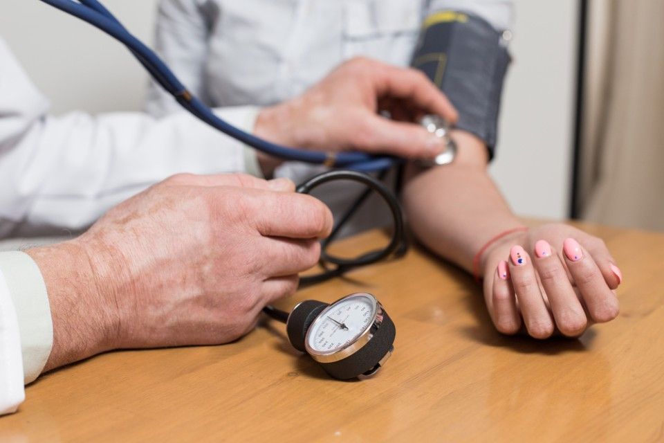 Arzt misst den Puls einer Patientin