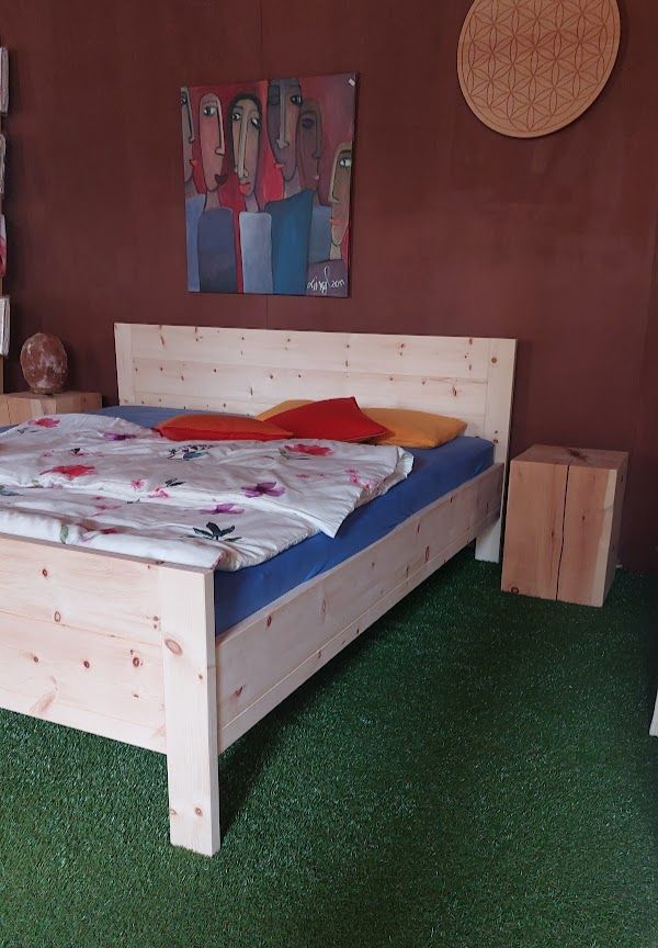 Holzbett mit weißer Bettwäsche, Kissen, Kunst an einer braunen Wand