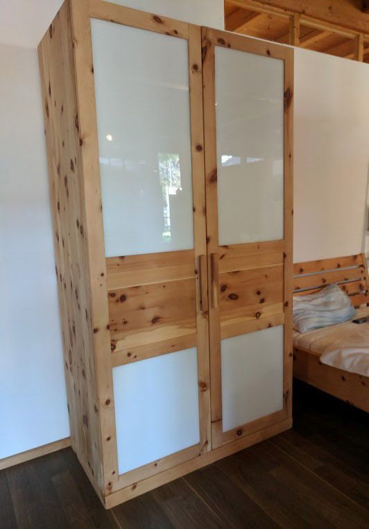 Holzschrank mit Glastüren; steht in einem Zimmer