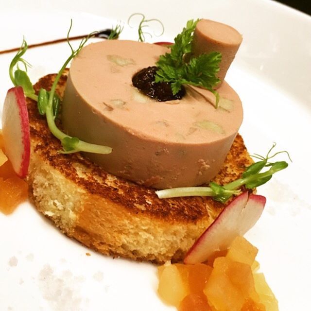 Foie-gras-Terrine auf geröstetem Brot, garniert mit Erbsensprossen
