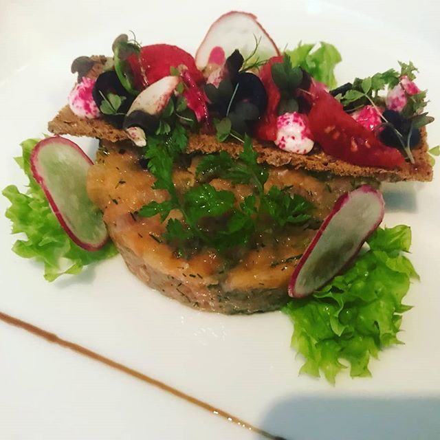 Gourmet-Vorspeise: Lachstatar, Cracker, Tomaten, Radieschen