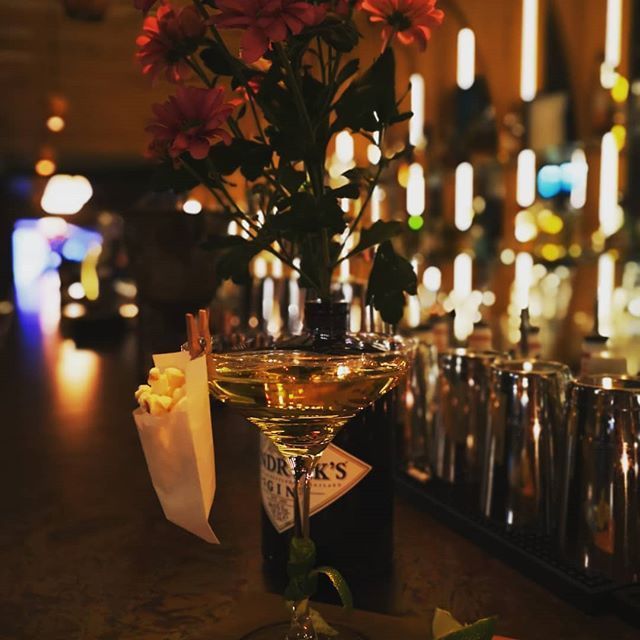 Cocktail mit Blumen und Popcorn auf einer Bar