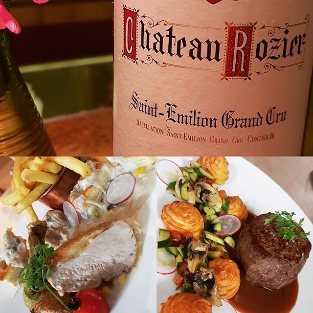 Eine Flasche Wein und Gourmetgerichte: Steak mit Soße