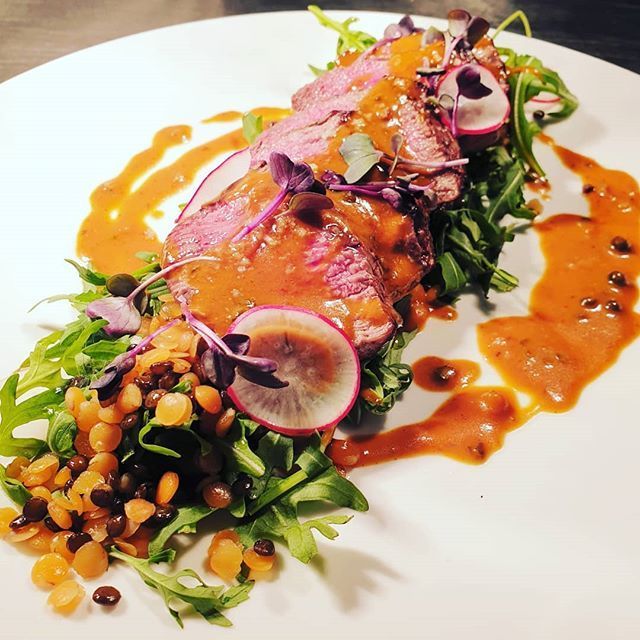 Geschnittene Entenbrust mit Sauce, Gemüse, Linsen und Radieschen