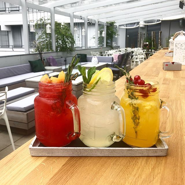 Drei farbenfrohe Getränke in Einmachgläsern auf einem Tablett