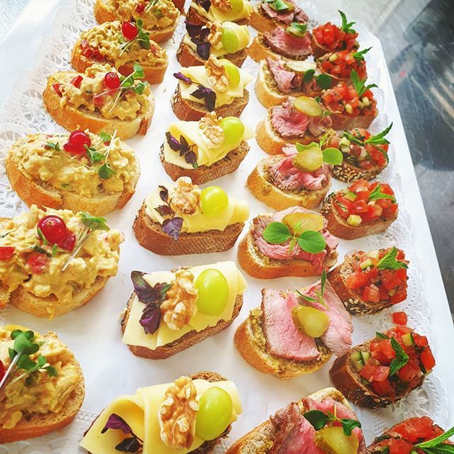 Tablett mit verschiedenen, mundgerechten Vorspeisen auf geröstetem Brot