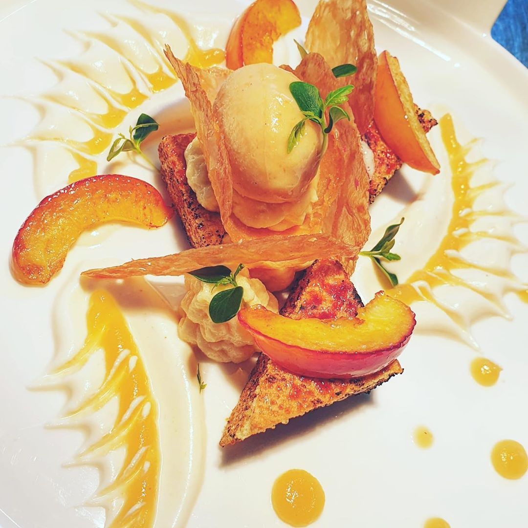 Dessert mit Pfirsichscheiben, Eiscreme und knusprigen Waffeln