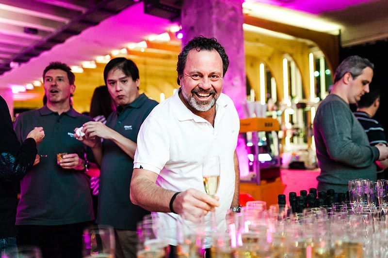 Ein lächelnder Mann hält ein Champagnerglas auf einer Party