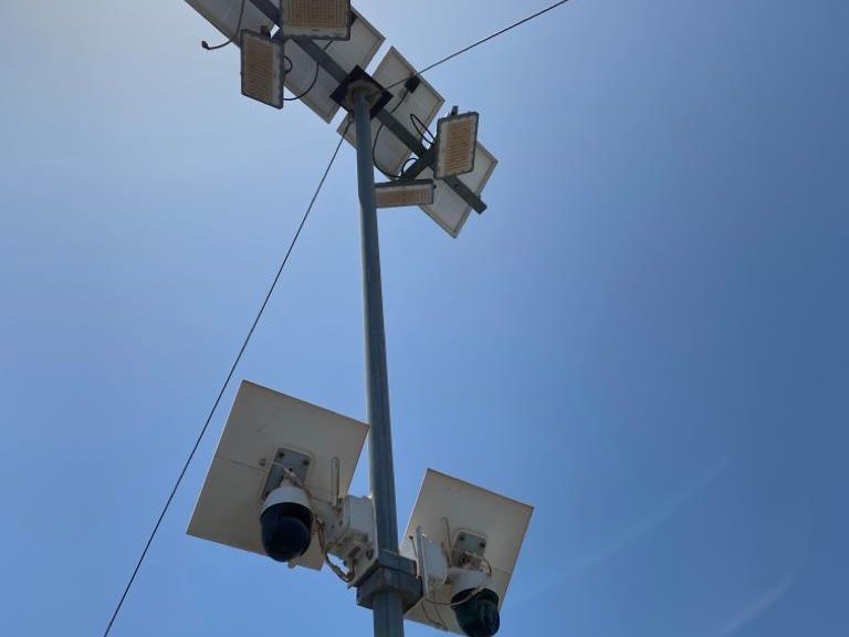 Un poste con un montón de altavoces contra un cielo azul.