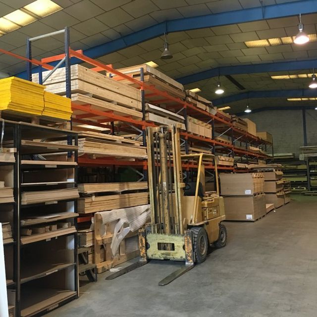 Una carretilla elevadora está estacionada en un gran almacén