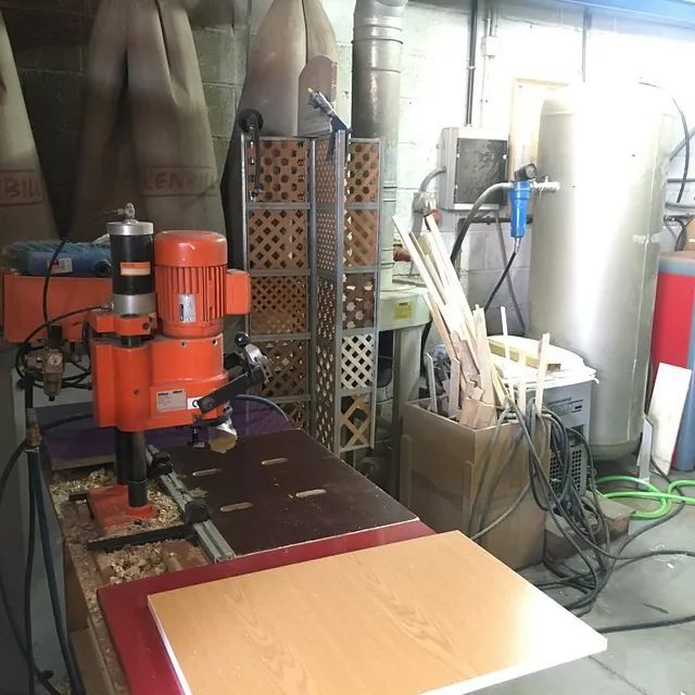 Una máquina de naranjas está encima de una mesa de madera.