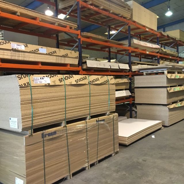 Un almacén lleno de madera contrachapada, incluido uno que dice 