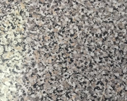 Un primer plano de una encimera de granito con una textura granulada.