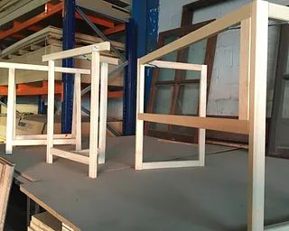 Un montón de marcos de madera están colocados encima de una mesa en un almacén.