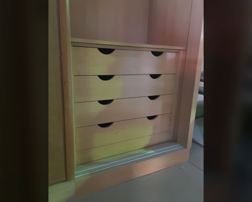 Una cómoda con cuatro cajones y una puerta corredera