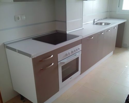 Una cocina con estufa, horno, fregadero y gabinetes.