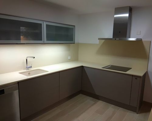 Una cocina con estufa, horno, fregadero y gabinetes.