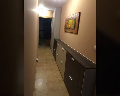 Un largo pasillo con un cuadro en la pared.