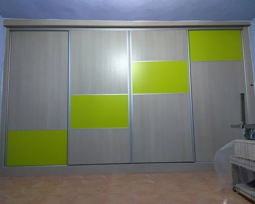Un gran armario con puertas correderas y paneles de color verde lima.