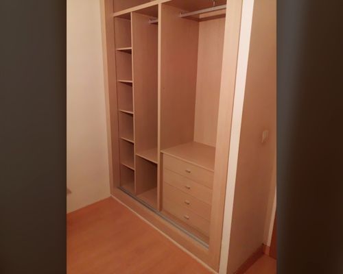 Un pequeño armario con estantes y cajones en una habitación.