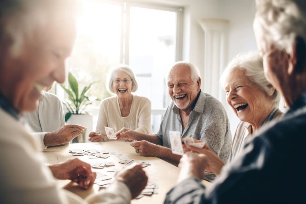 Eine Gruppe älterer Menschen sitzt an einem Tisch und spielt Karten.
