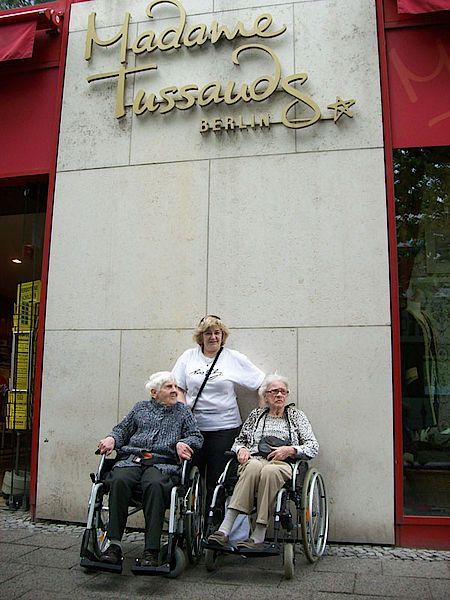 Drei Frauen im Rollstuhl posieren vor Madame Tussauds