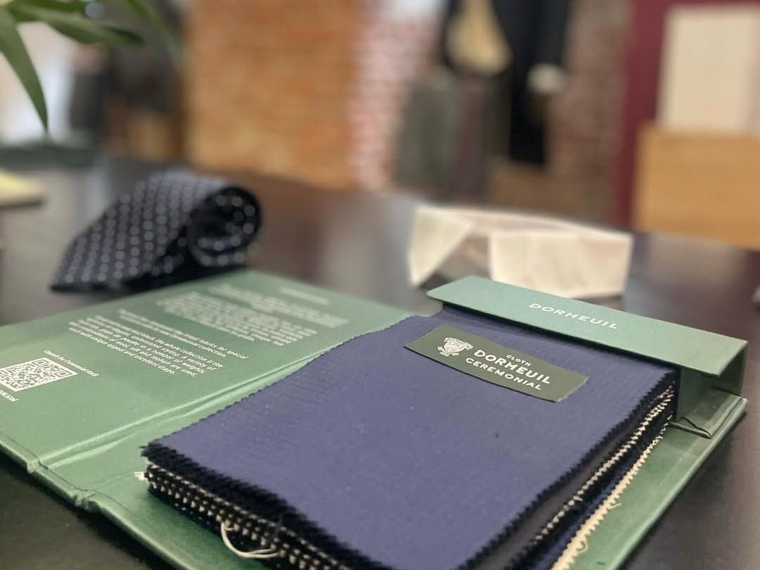 Un libro está sobre una mesa al lado de una corbata.