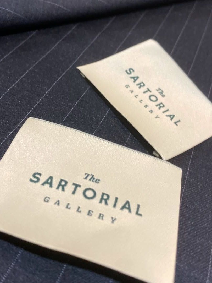 Dos etiquetas para la galería sartorial están en un trozo de tela