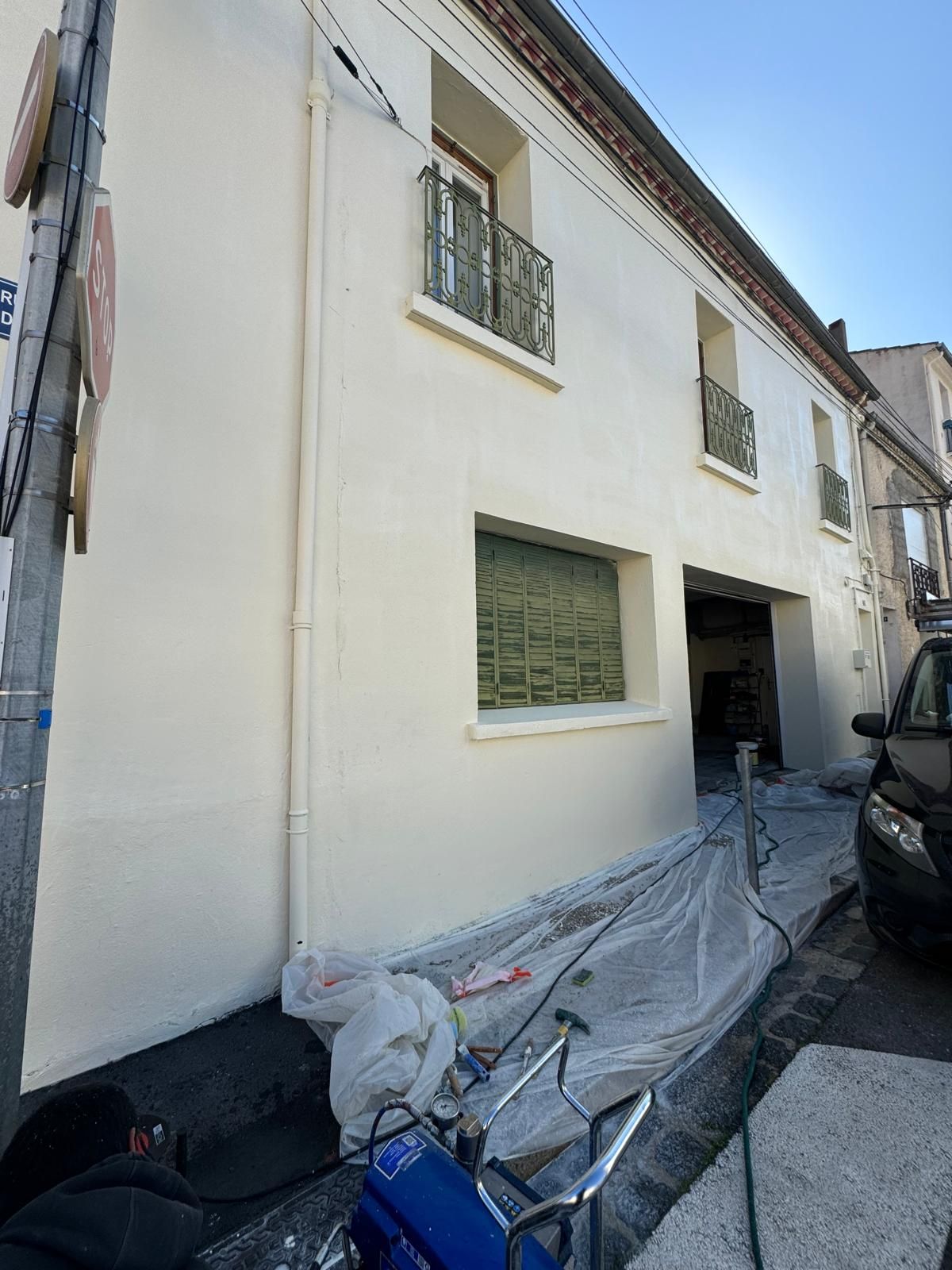 Maison en construction avec échafaudages et murs extérieurs blancs par une journée ensoleillée