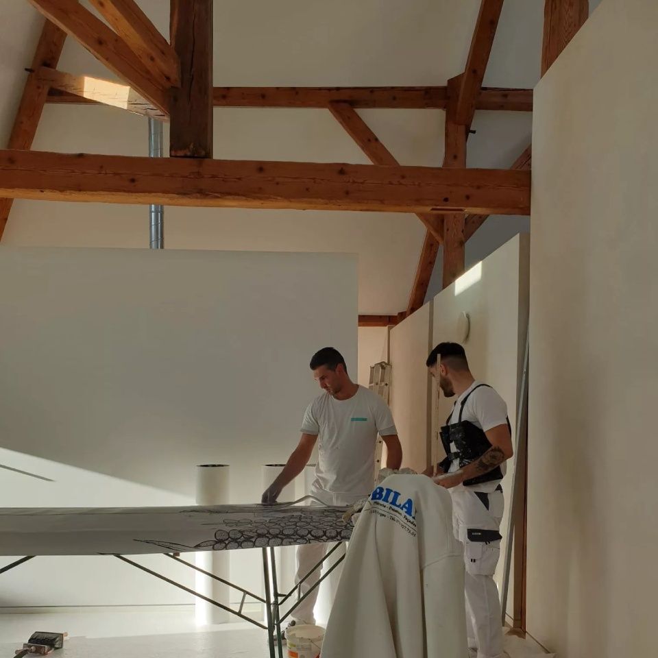 Deux hommes debout à côté d'une table avec une veste sur laquelle est écrit Bilal