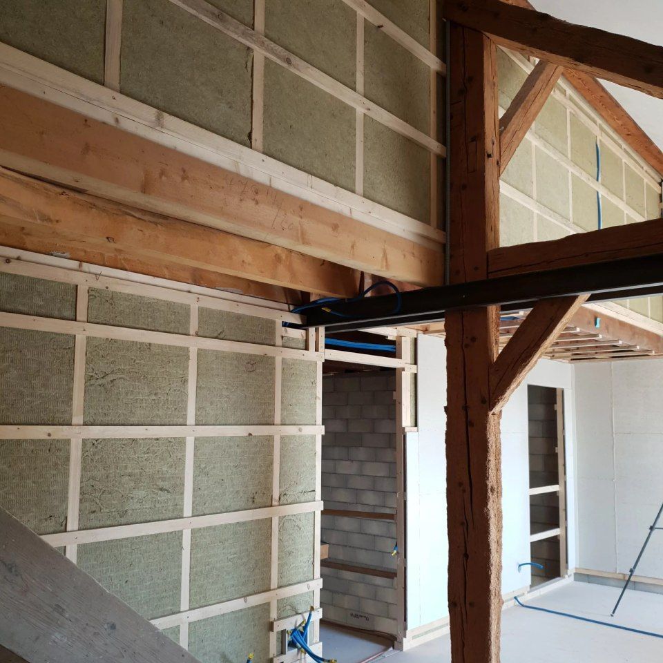 Une pièce avec une ossature en bois et des murs en briques