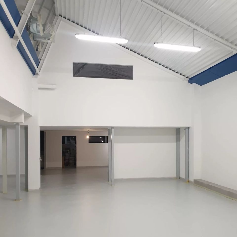 Une grande pièce vide avec des murs blancs et un plafond bleu