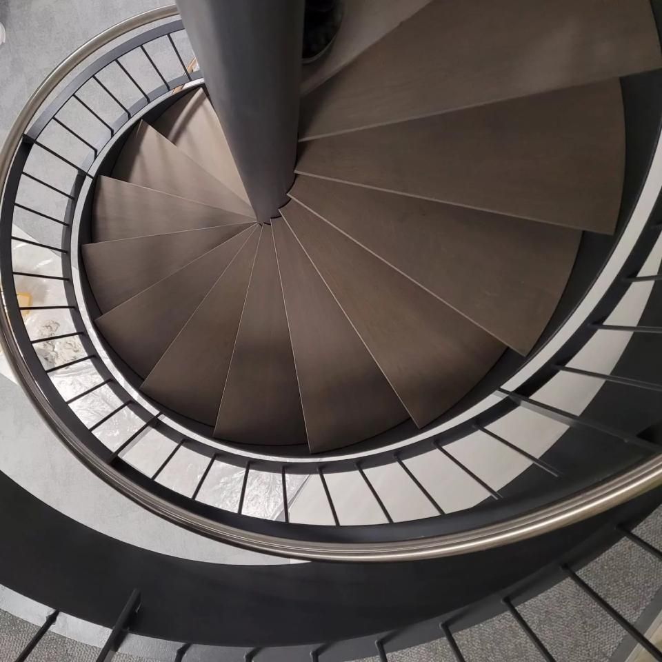 Un escalier en colimaçon avec une rampe en acier inoxydable