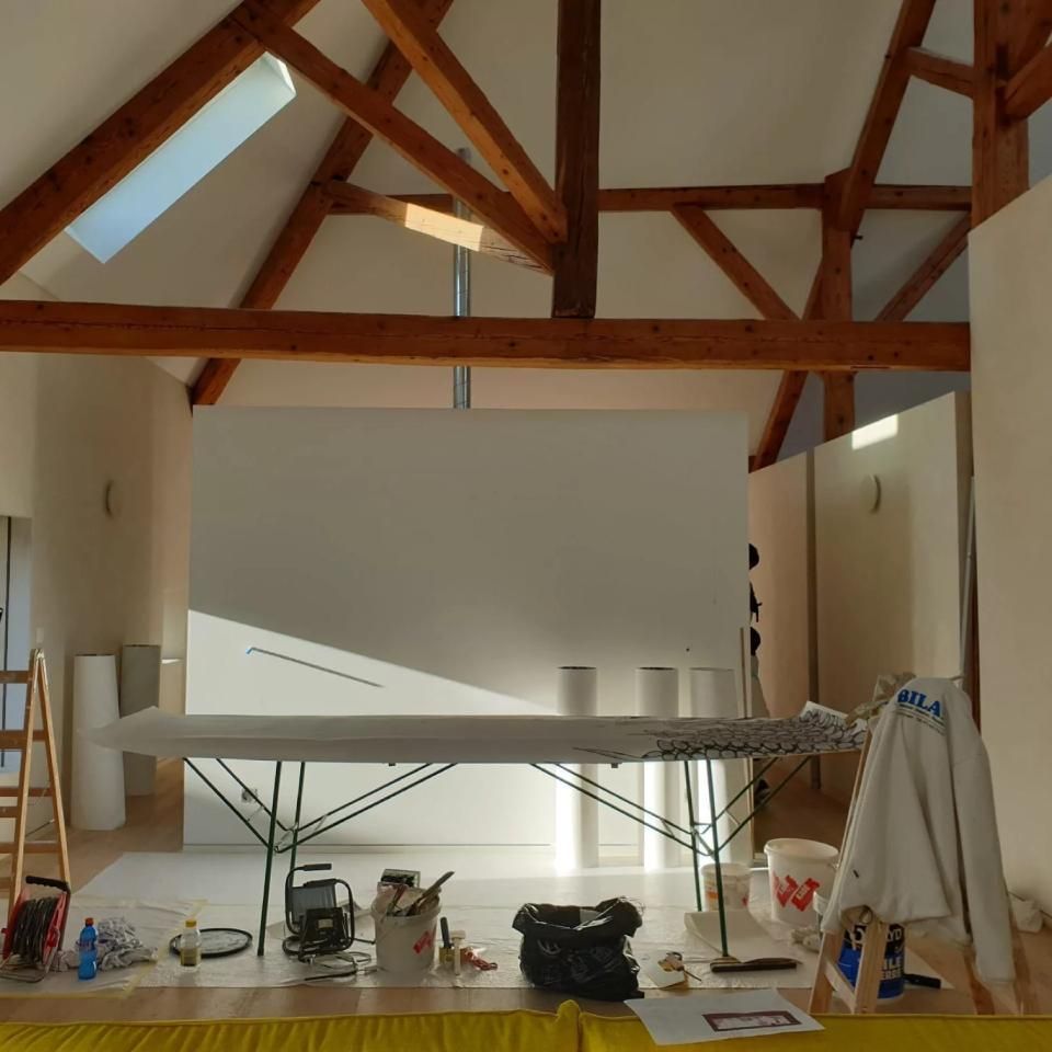 Une pièce avec des poutres en bois et une table blanche