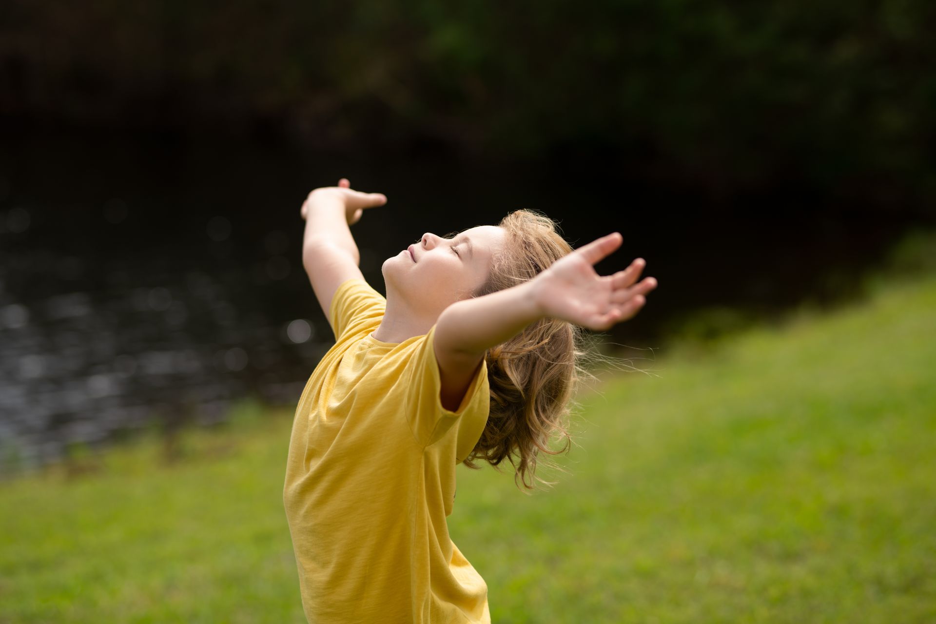 Un enfant qui a les bras et la tête vers le ciel
