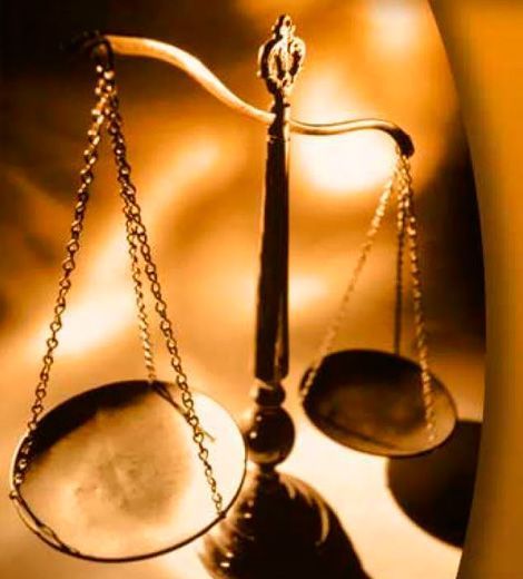 Un primer plano de una balanza de la justicia sobre una mesa.